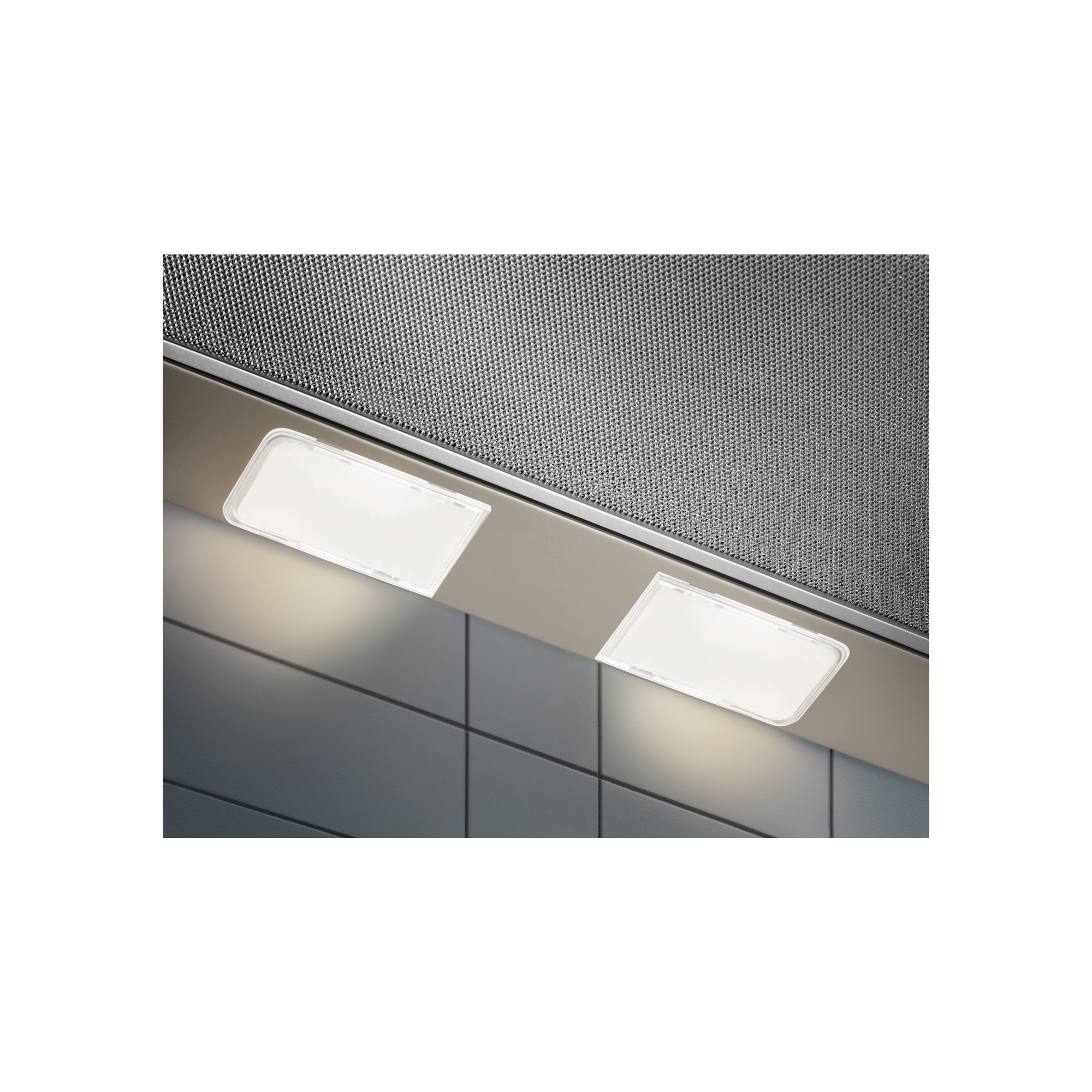 Dwa prostokątne światła oświetlają szarą, kafelkową ścianę pod okapem.