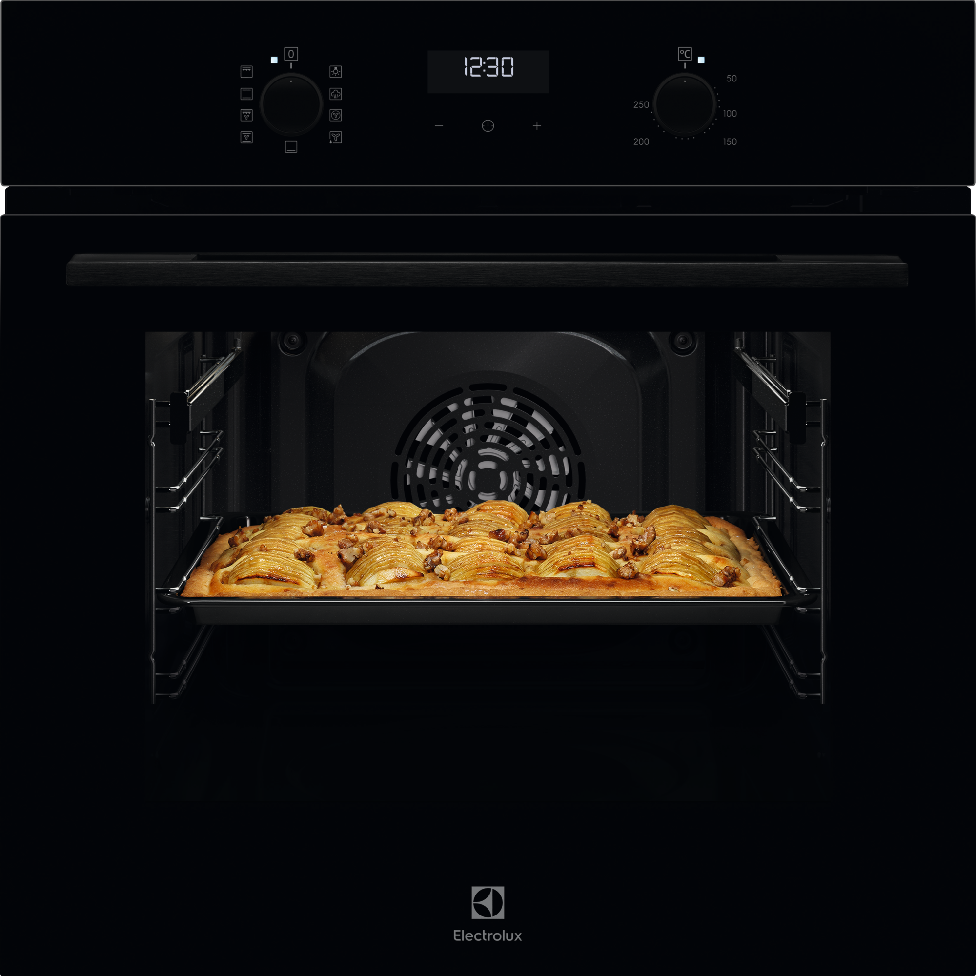 Upieczone ciasto z plasterkami jabłek i orzechami w czarnym piekarniku.