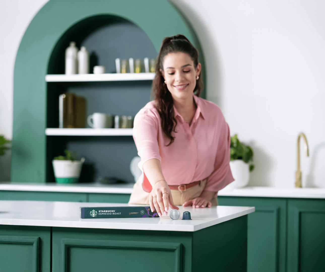Una donna sceglie capsule di caffè in una cucina moderna.