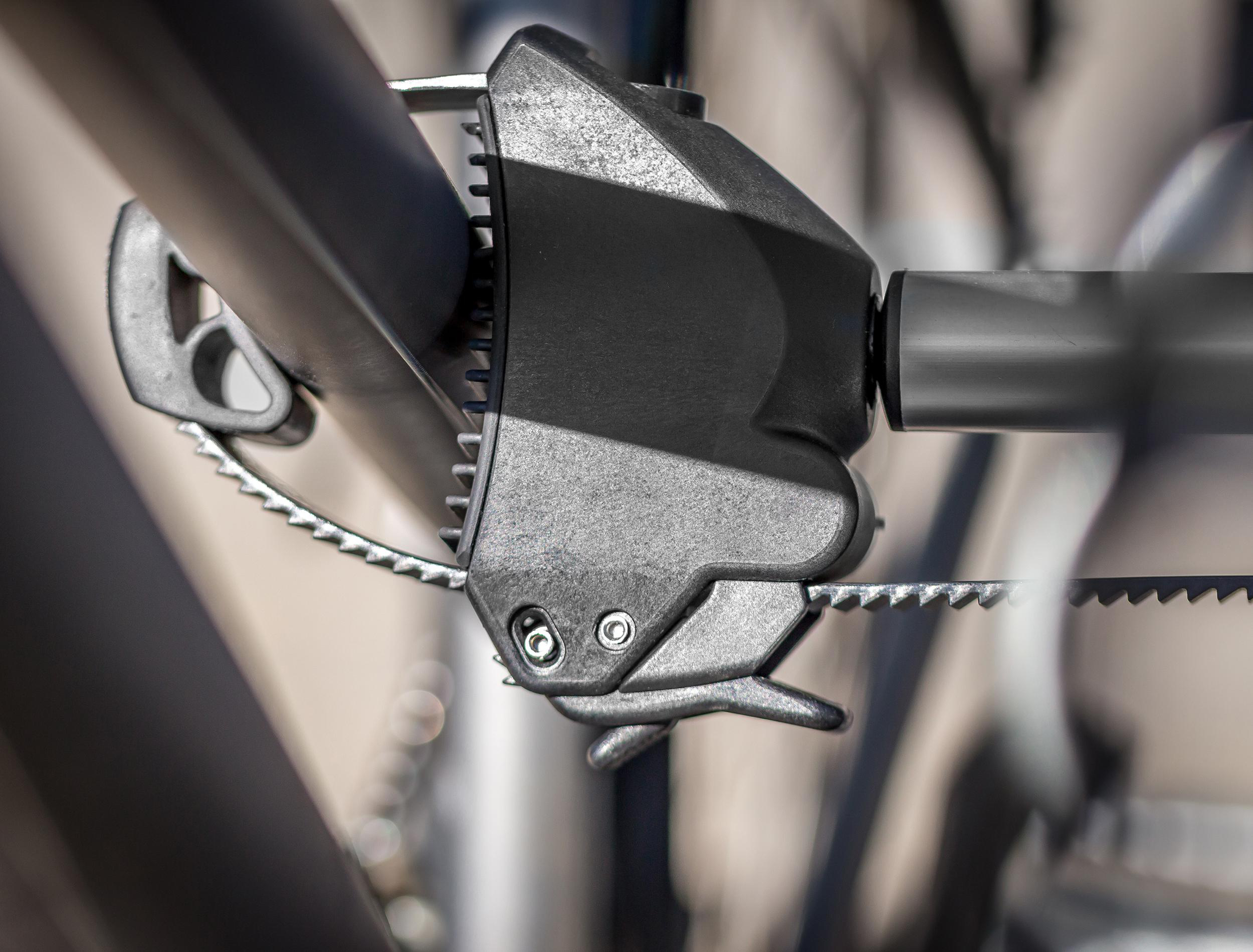 Nahaufnahme eines schwarzen Fahrrad-Schnellspannhebels mit Zahnrad und Kette.