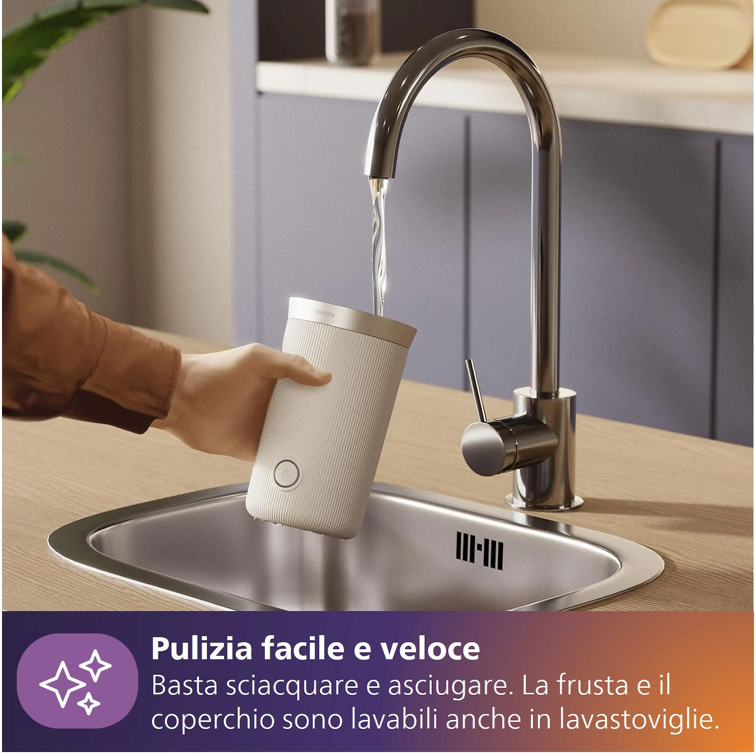 Una mano sciacqua una tazza bianca sotto un rubinetto in un lavello.