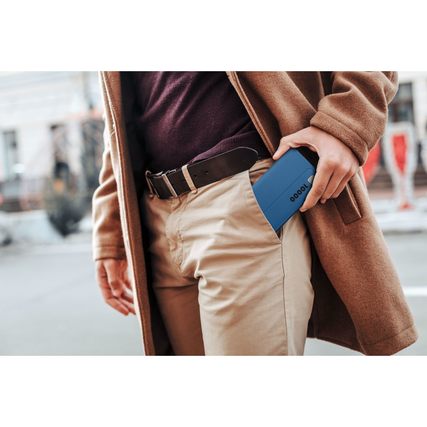 Uomo in cappotto marrone mette power bank blu 10000 in tasca.