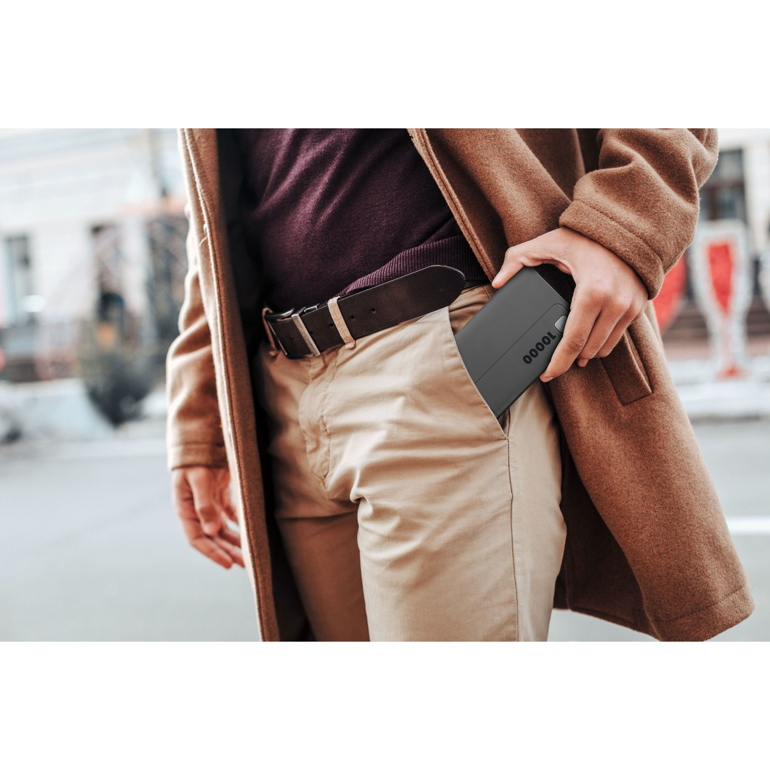 Un uomo mette un power bank nero in tasca.
