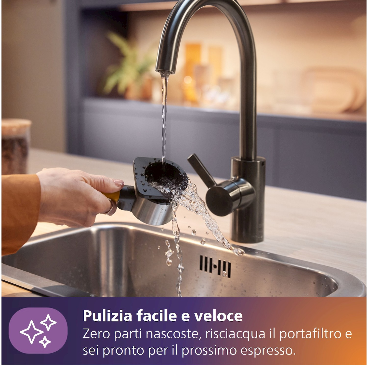 Un portafiltro viene sciacquato sotto acqua corrente in un lavello.