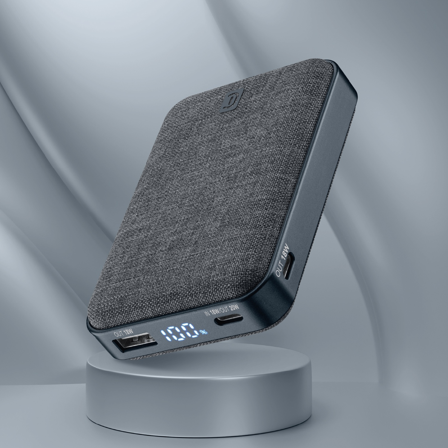 Power bank grigio in tessuto con display digitale 100% su piedistallo.