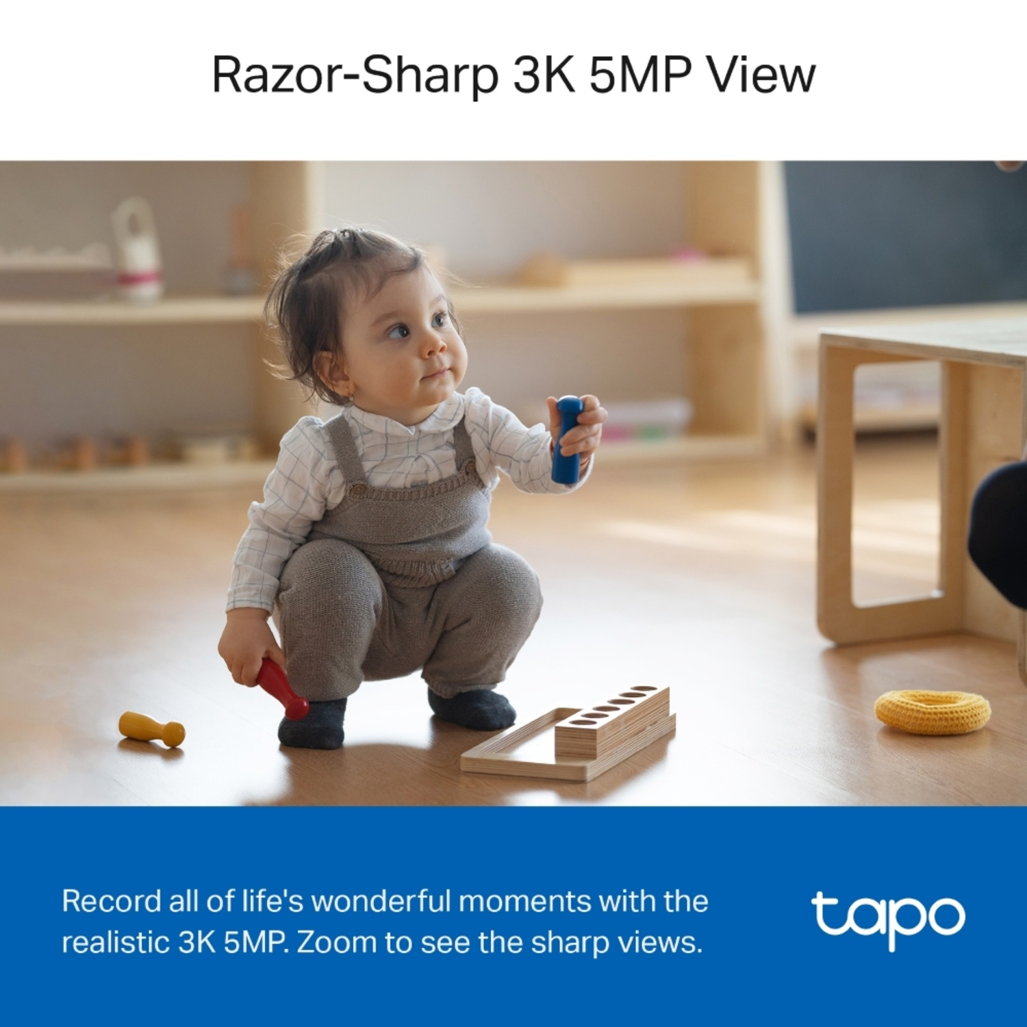 A baby kneels on the floor playing with toys.