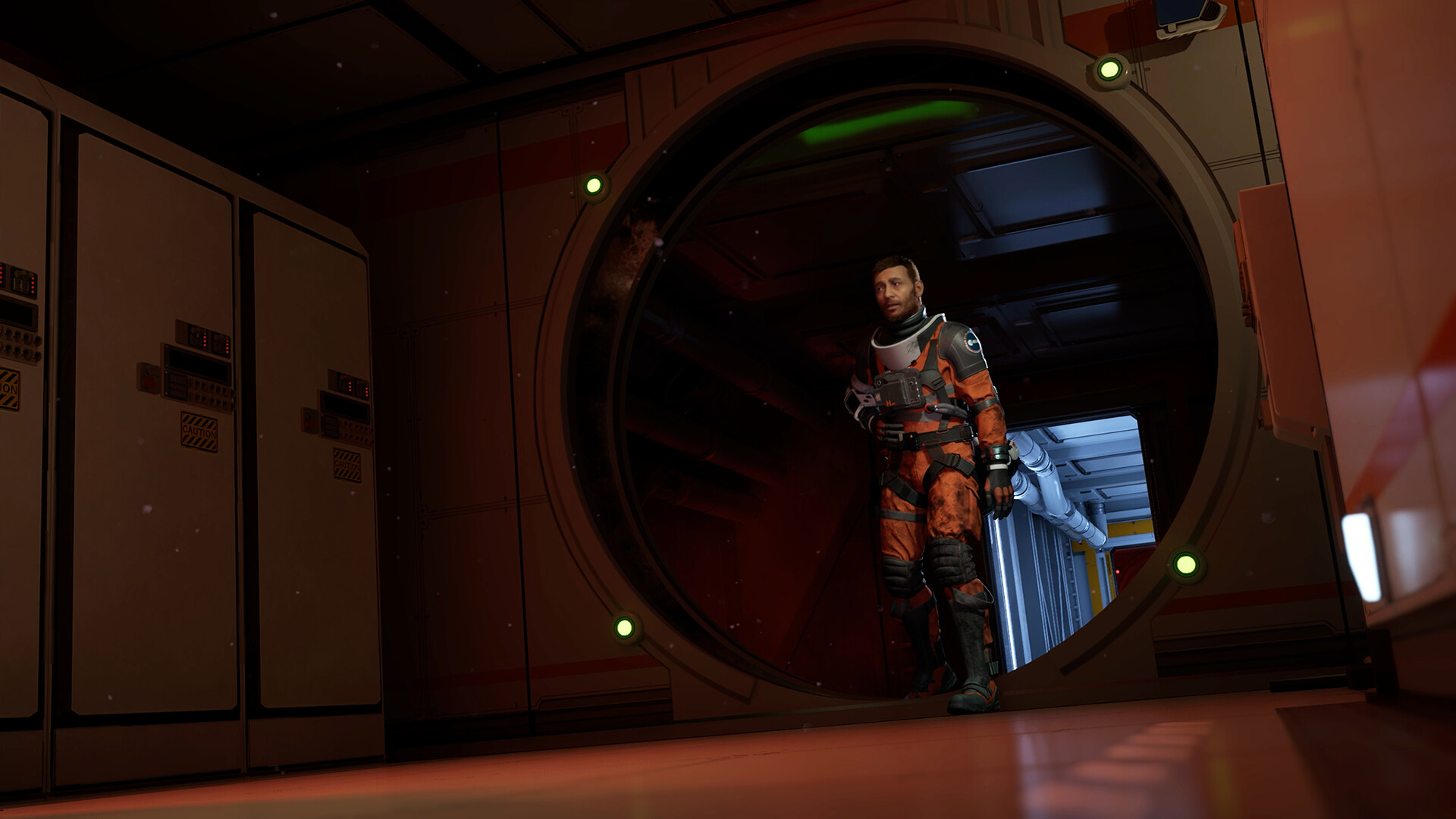 Un homme en combinaison spatiale orange et noire se tient dans un couloir de vaisseau spatial faiblement éclairé, regardant à travers une porte circulaire.