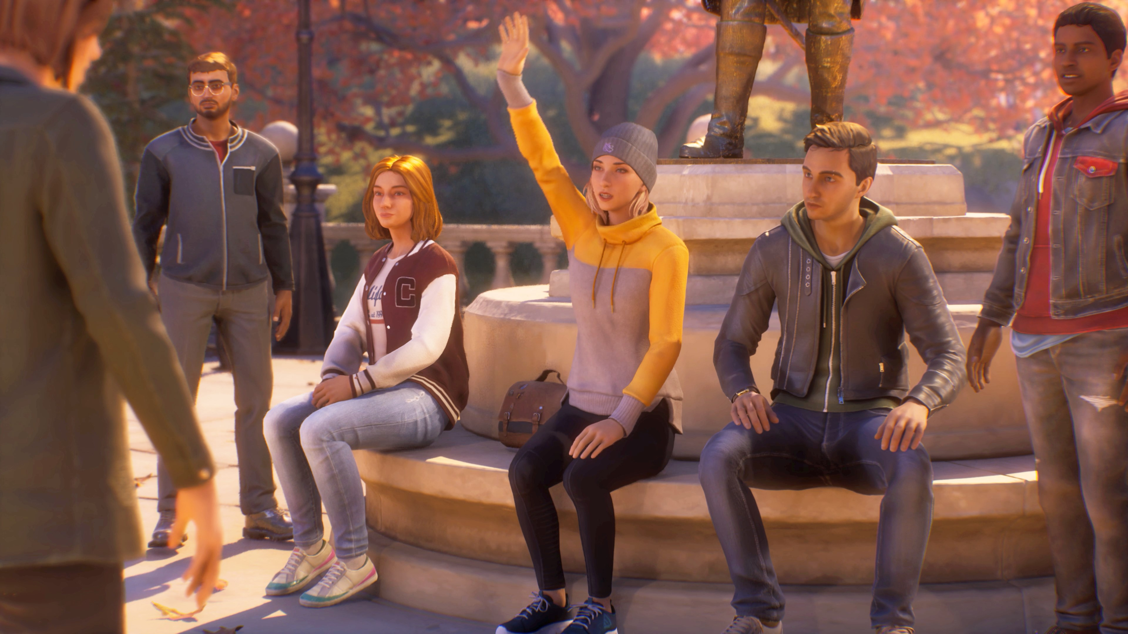 Un groupe de jeunes gens assis et debout à l'extérieur devant une statue.