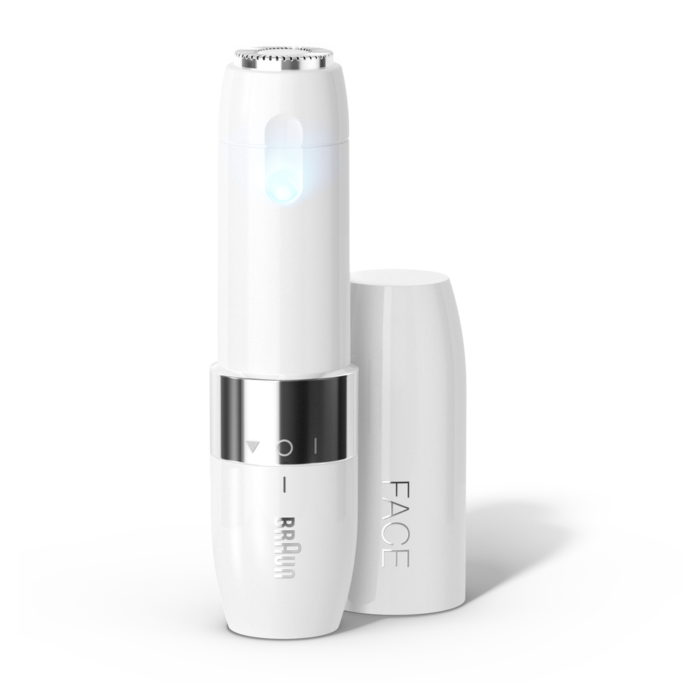 Un depilador facial Braun blanco con anillo plateado y LED azul. Tapa a su lado.