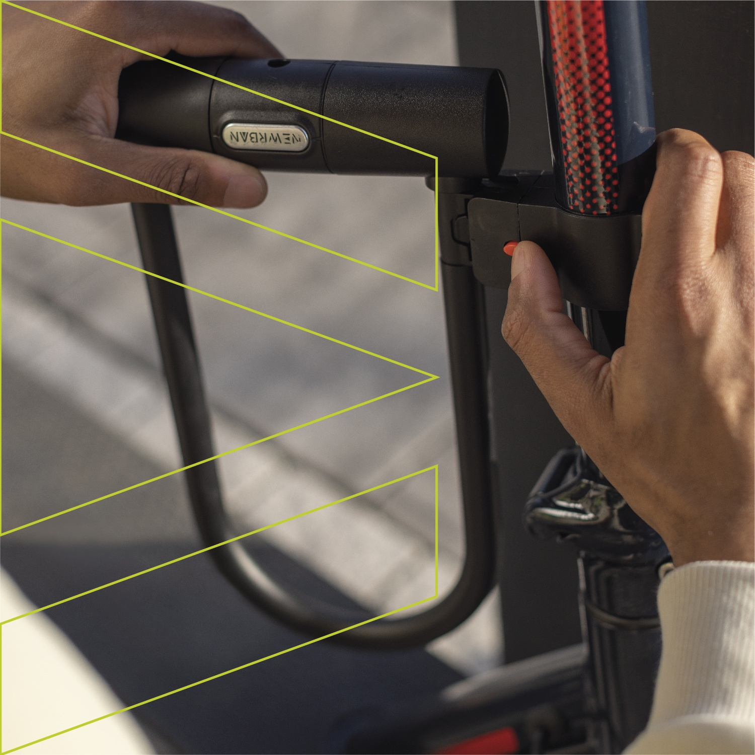 Persona che chiude lucchetto bicicletta. Mani azionano pulsante rosso e lucchetto.