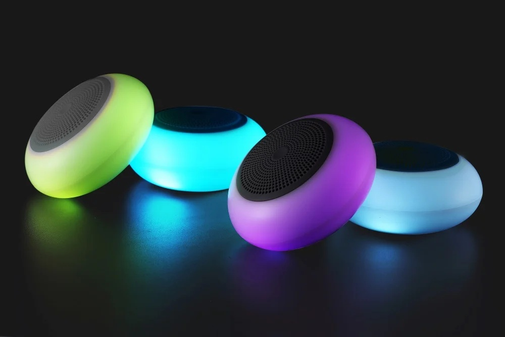 Cztery podświetlone głośniki w kolorach zielonym, niebieskim, fioletowym i jasnoniebieskim na ciemnym tle.