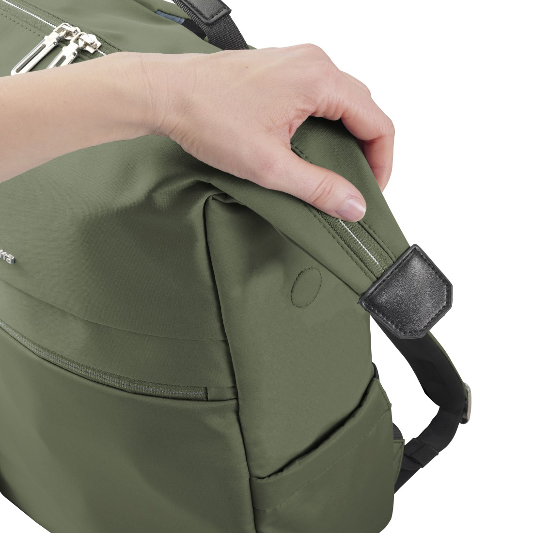 Eine Hand greift nach dem Reißverschluss einer olivgrünen Tasche.
