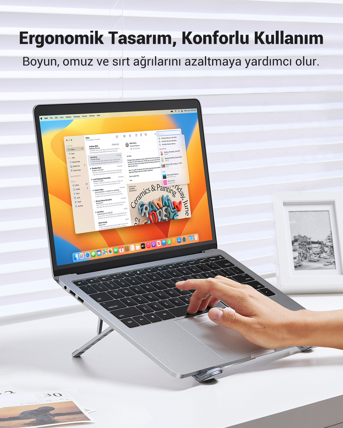 Bir dizüstü bilgisayar stant üzerinde duruyor, bir el klavyede yazıyor.