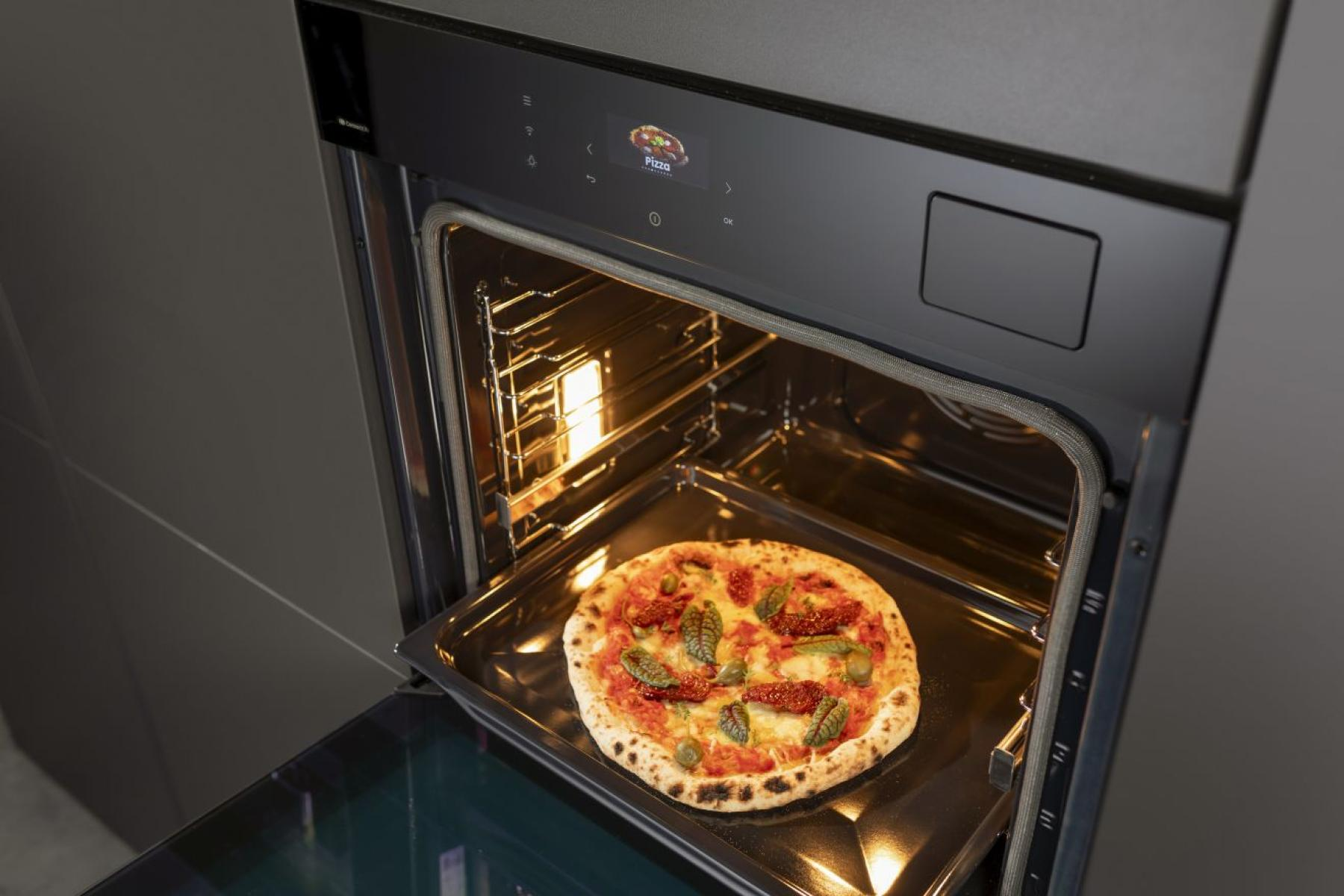 Pizza egy tepsiben, sütőben.