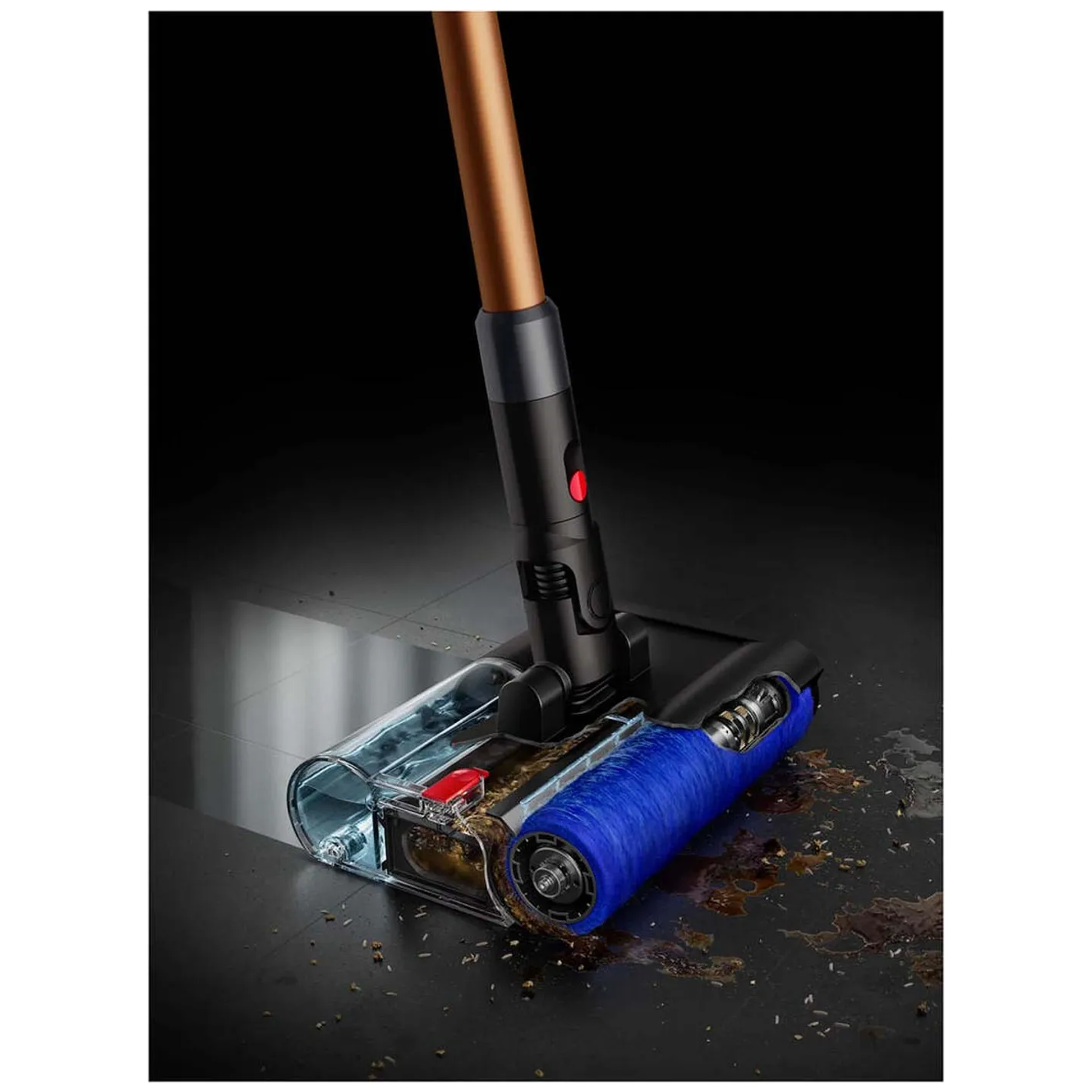 A vacuum cleaner with a blue brush head sucks up dirt from a dark floor.