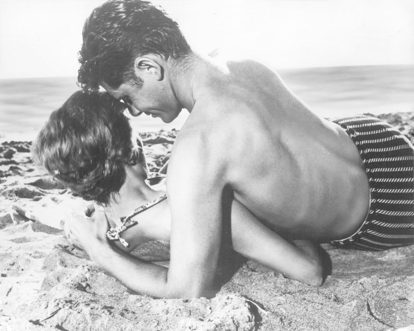 Ein Mann und eine Frau liegen am Strand. Die Sonne scheint.