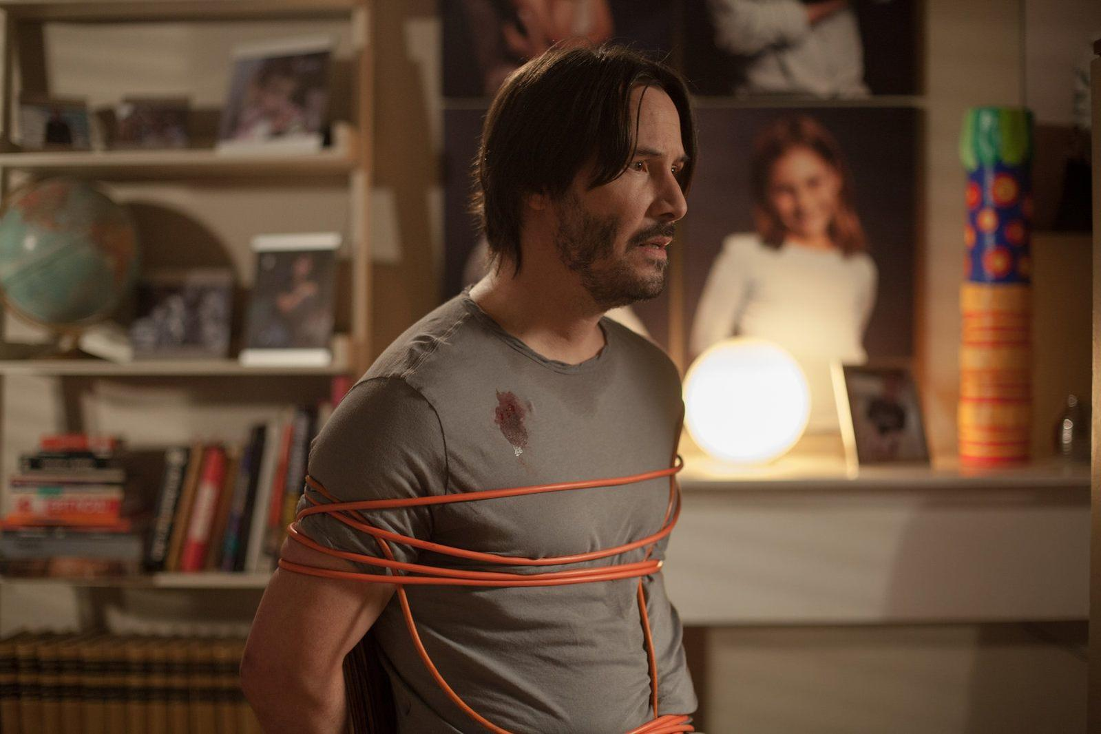 Mann mit orangefarbenem Kabel gefesselt, roter Fleck auf dem T-Shirt.