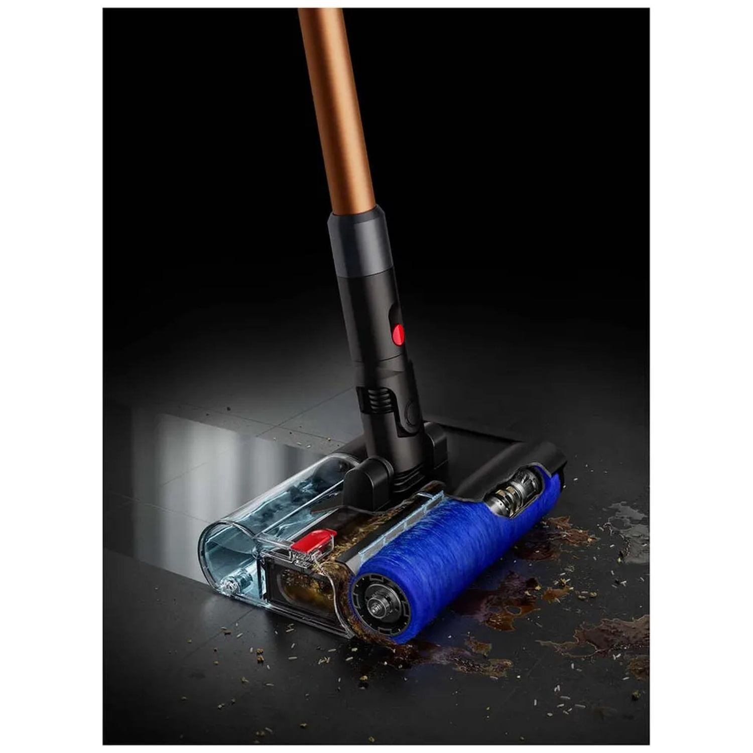 Aspirateur avec tête de brosse bleue et bac à poussière sur sol sale.