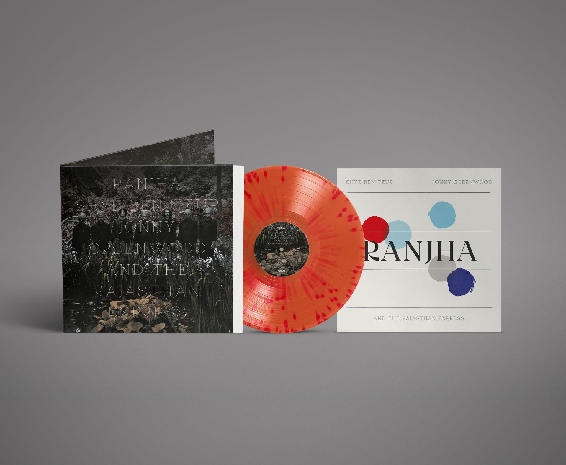 Eine orangefarbene Schallplatte mit roten Sprenkeln neben zwei Album-Covern.