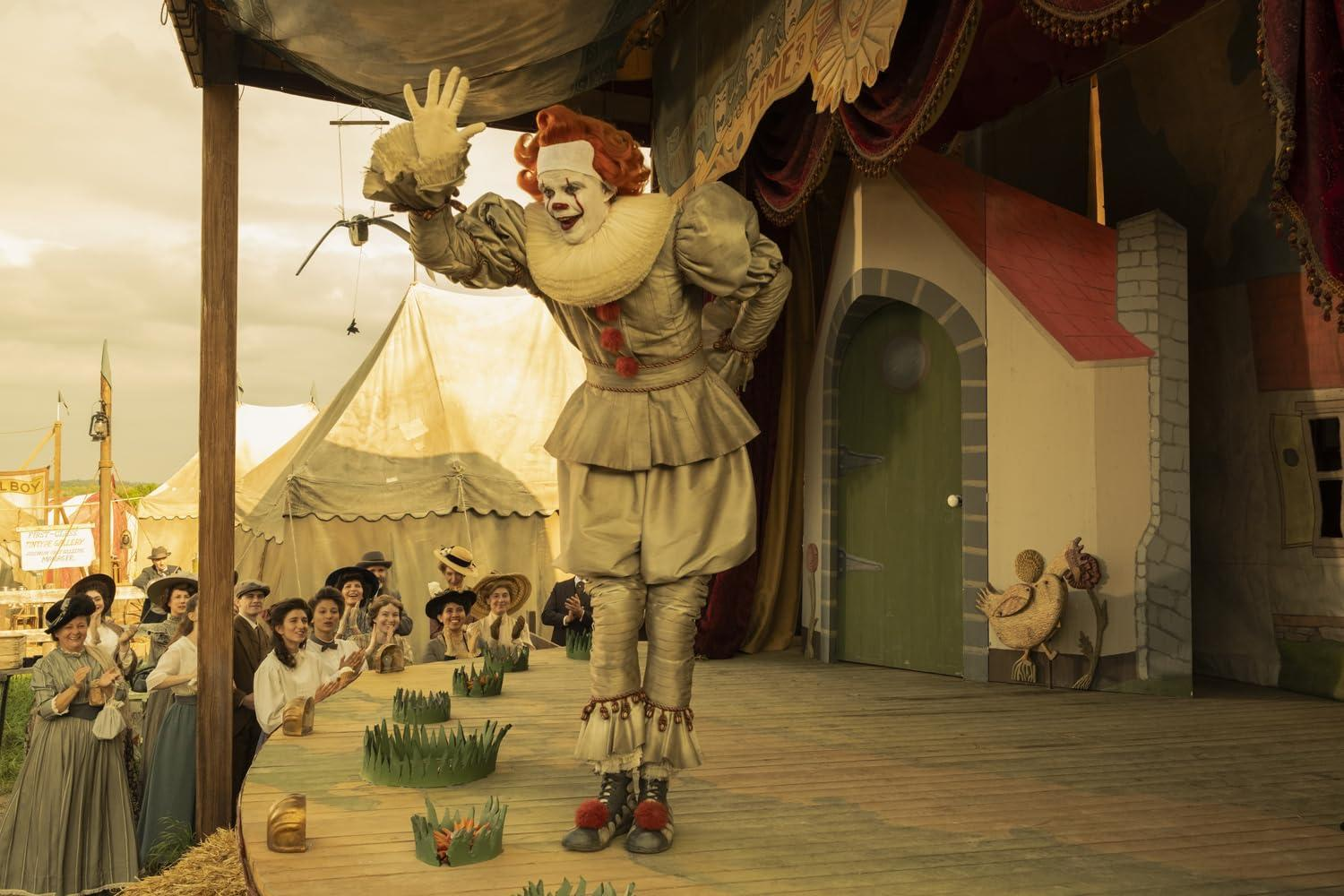 Ein Clown winkt einer Menge von einem Jahrmarkt-Podest zu.