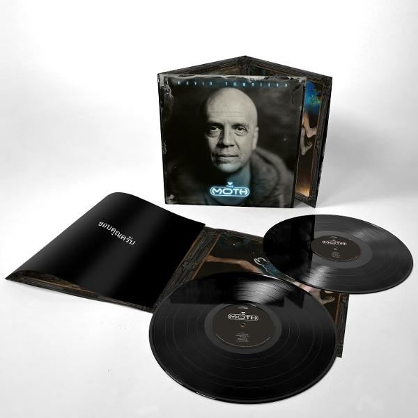 Ein Vinyl-Album mit Devin Townsend auf dem Cover, zwei schwarze Schallplatten liegen daneben.