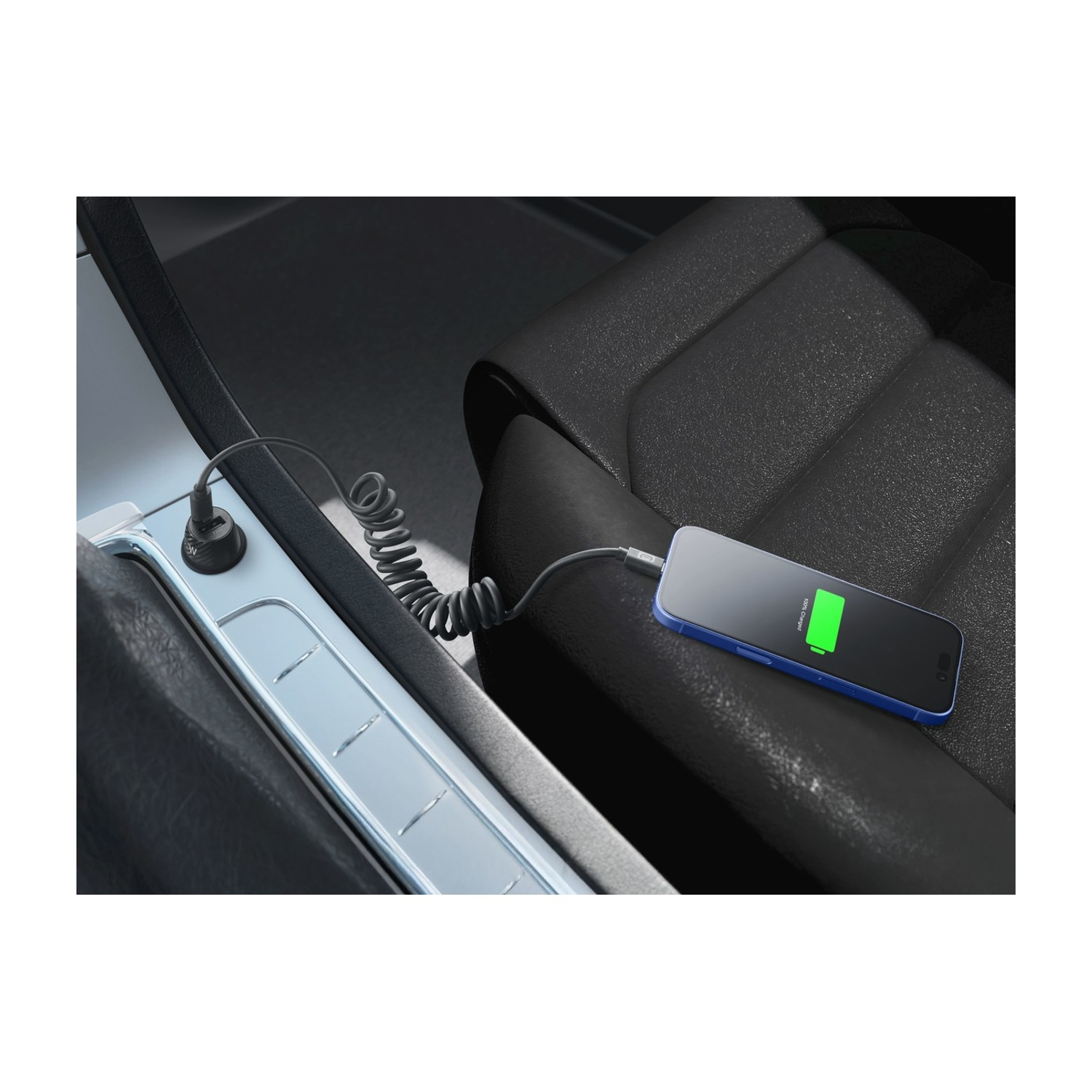 Uno smartphone blu viene caricato in auto tramite cavo a spirale.