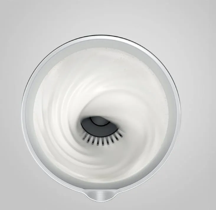 Biała spirala spienionego mleka w pojemniku, stworzona przez spieniacz.