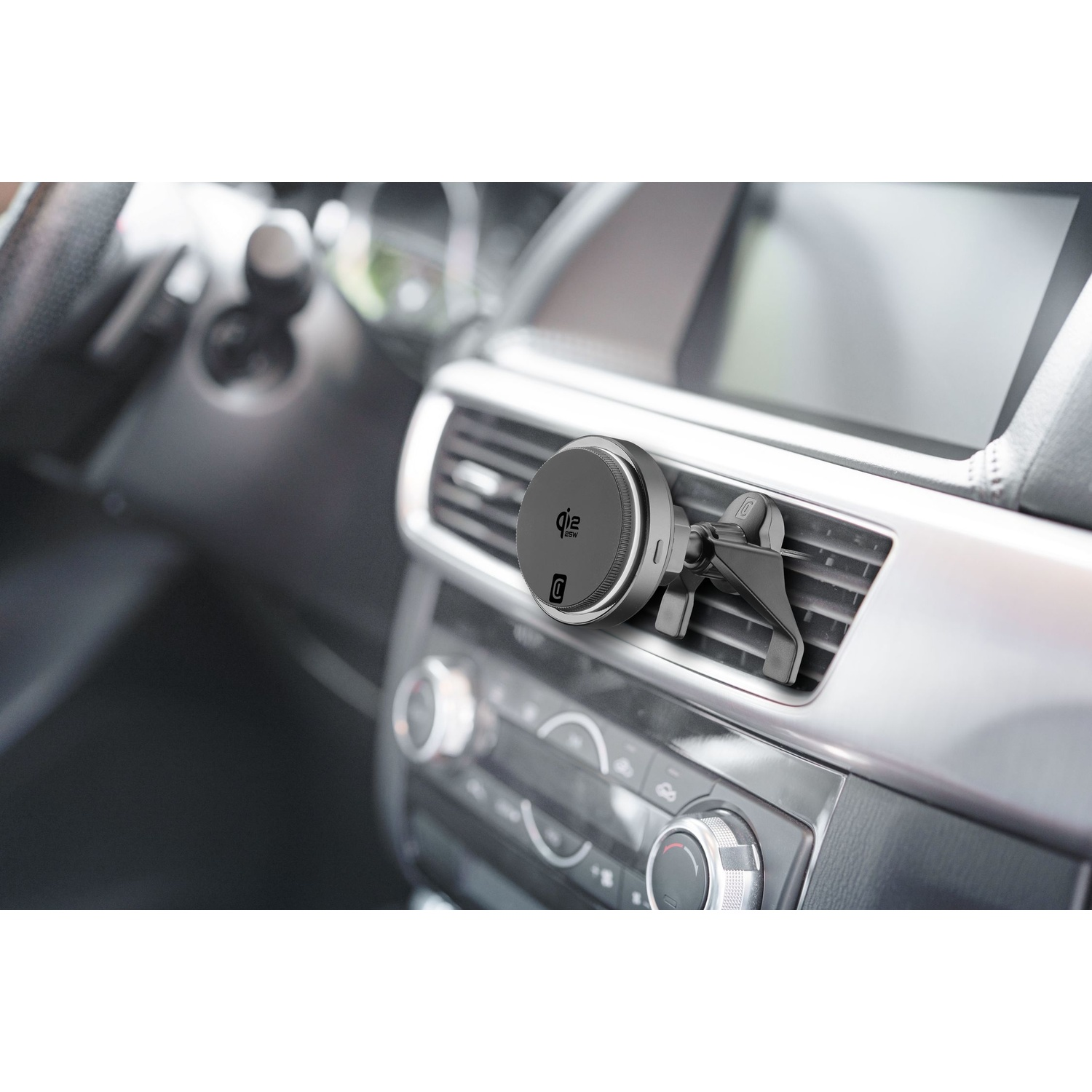 Un supporto magnetico grigio per telefono è attaccato a una bocchetta di ventilazione dell'auto.