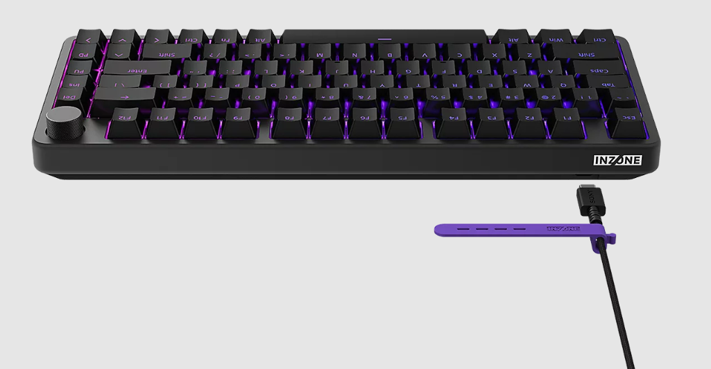 Schwarze Tastatur mit violetter Beleuchtung und Drehknopf. Ladekabel.
