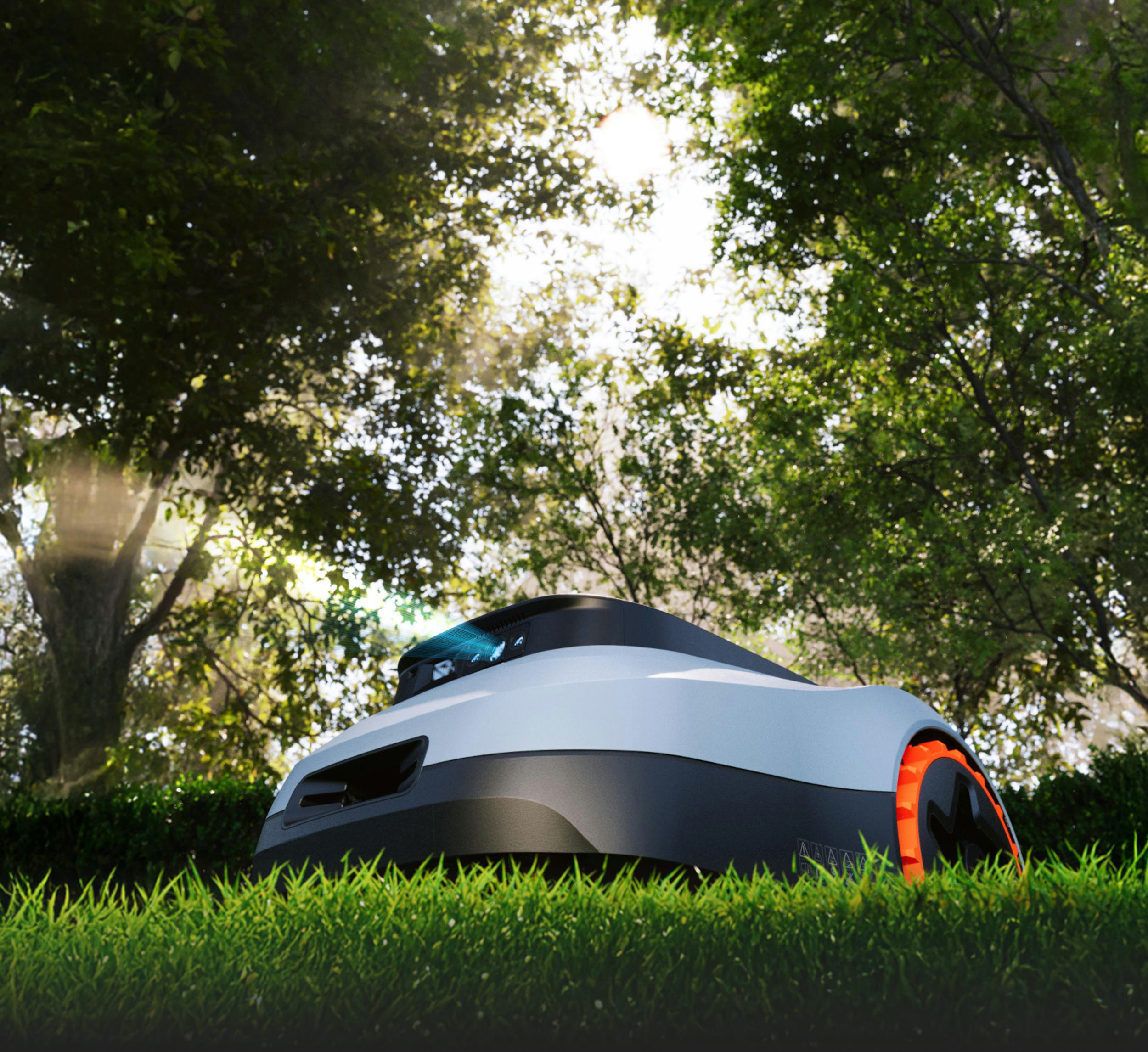 Ein weißer und grauer Mähroboter mit orangen Akzenten auf einem grünen Rasen unter Bäumen.