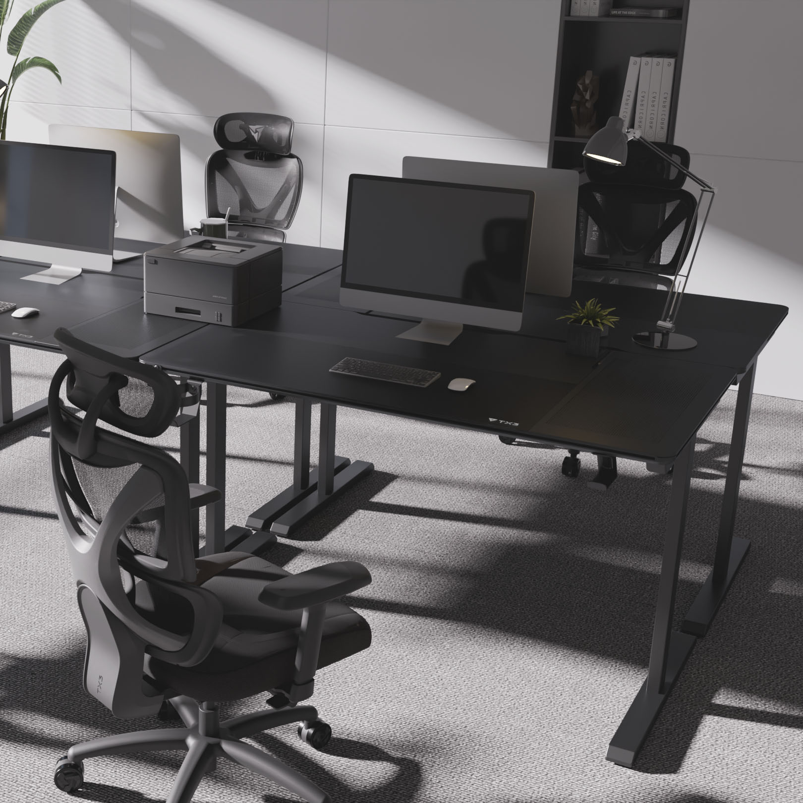 Ein modernes Büro mit schwarzen Schreibtischen, Computern, Stühlen und einem Drucker.