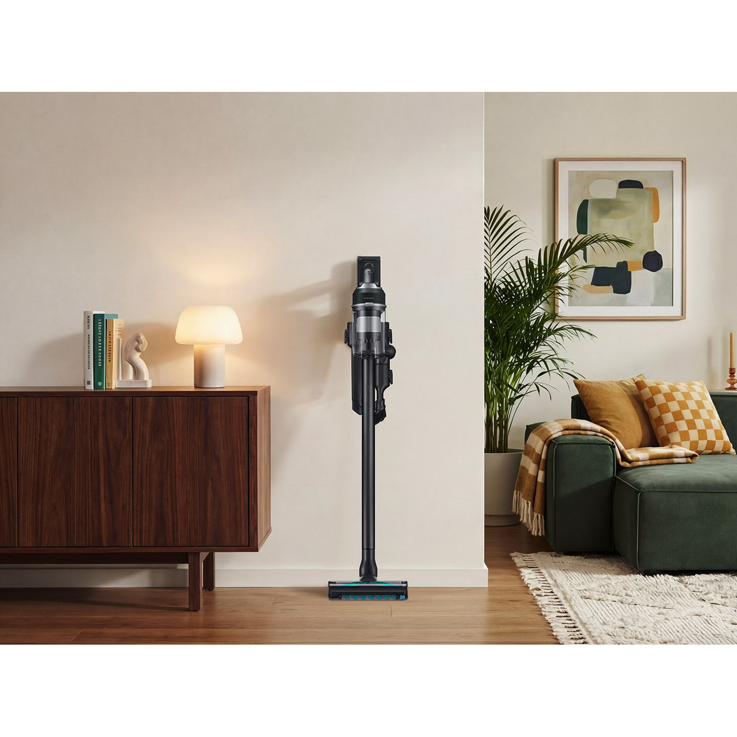 A black cordless vacuum cleaner stands on a wooden floor next to a wooden cabinet.