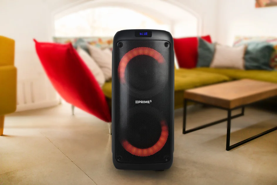 Czarny głośnik z czerwonymi światłami w salonie.