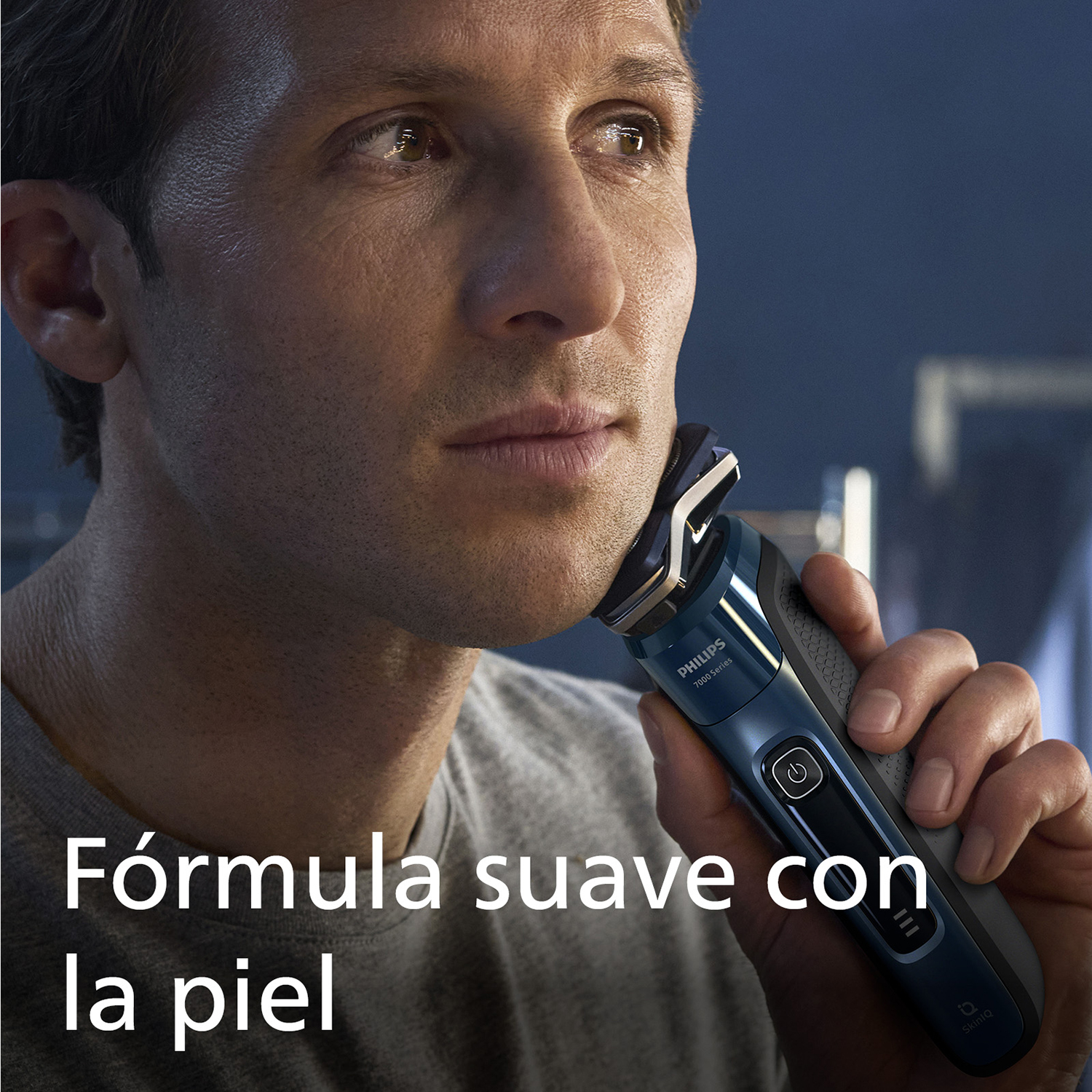 Un hombre se afeita con una afeitadora eléctrica Philips 7000 Series azul.