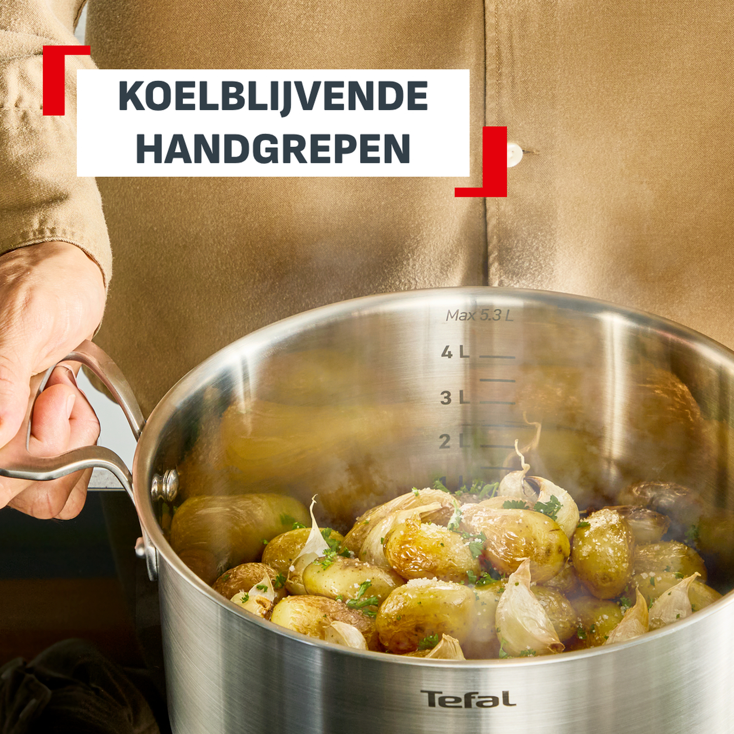 Pan met aardappelen en knoflook, vastgehouden door persoon.