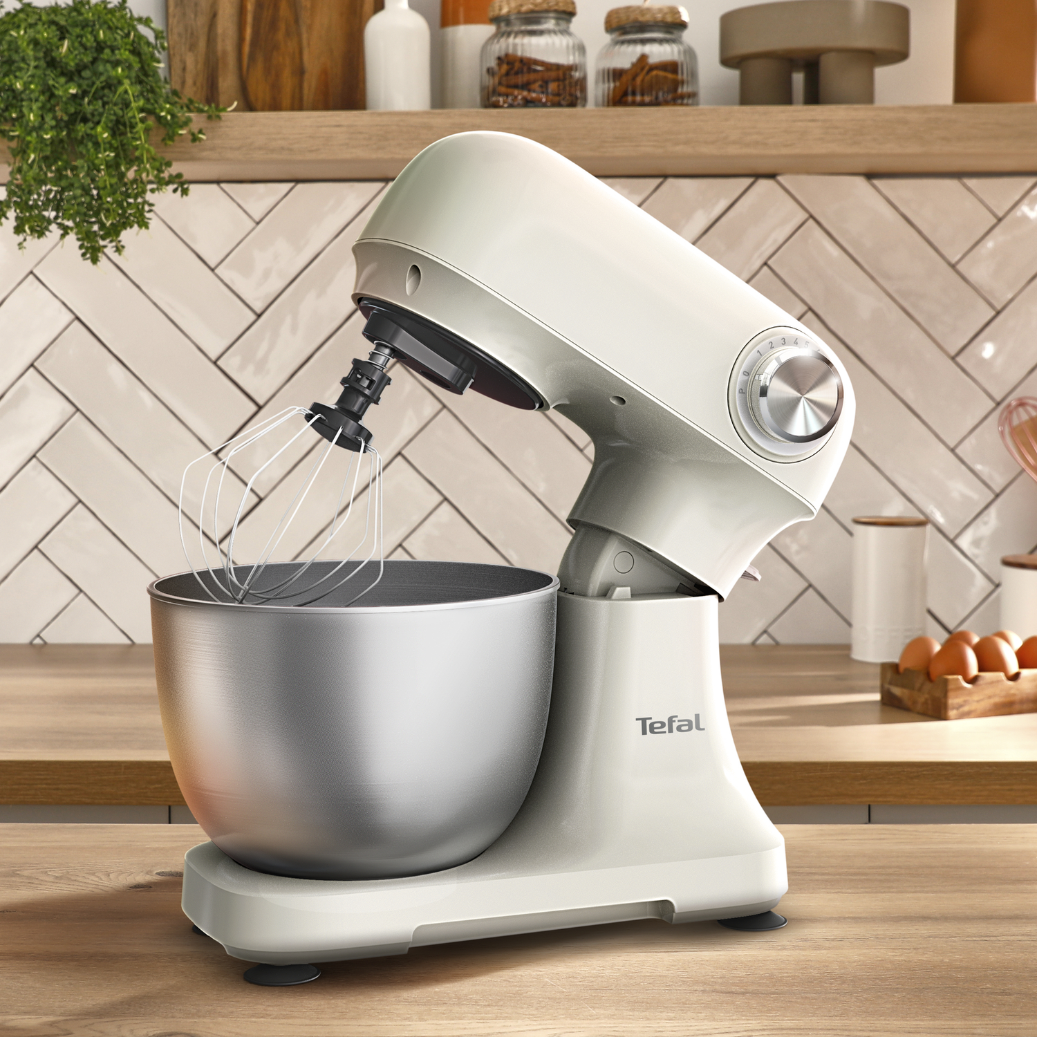 Een crème-kleurige standmixer met mengkom en garde.