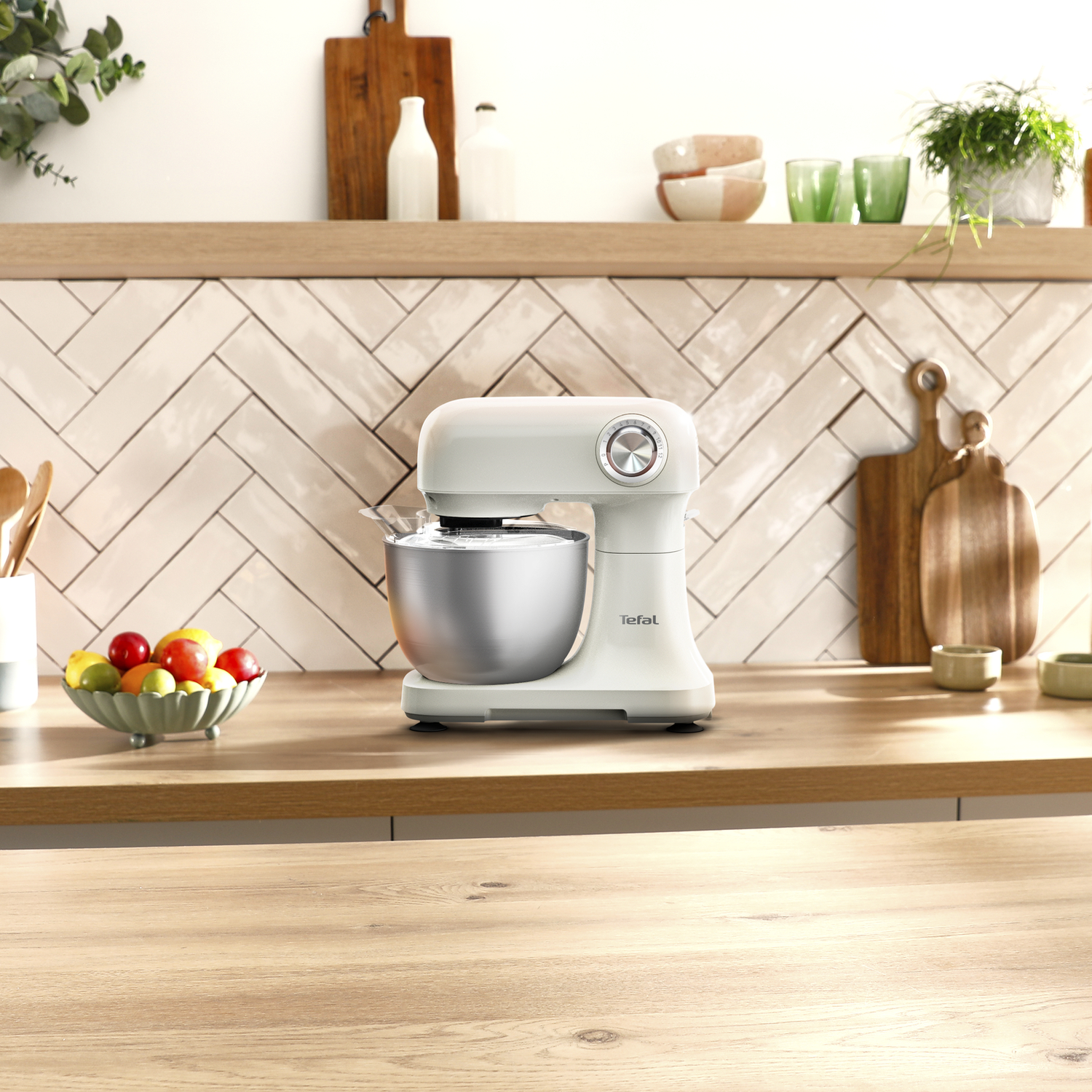 Een witte keukenmixer op een houten aanrecht voor een betegelde achterwand.