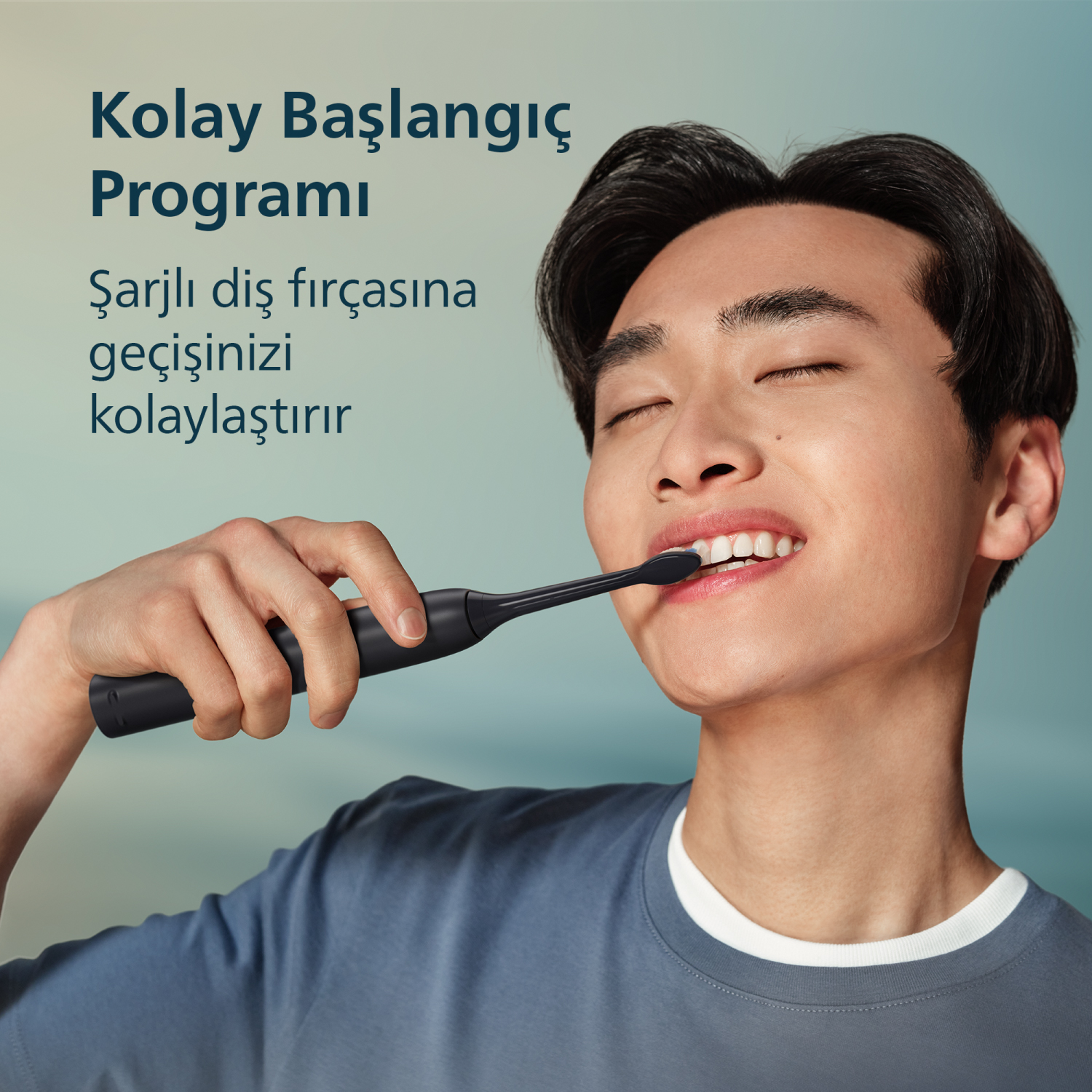 Gözleri kapalı bir adam siyah elektrikli diş fırçasıyla dişlerini fırçalıyor.