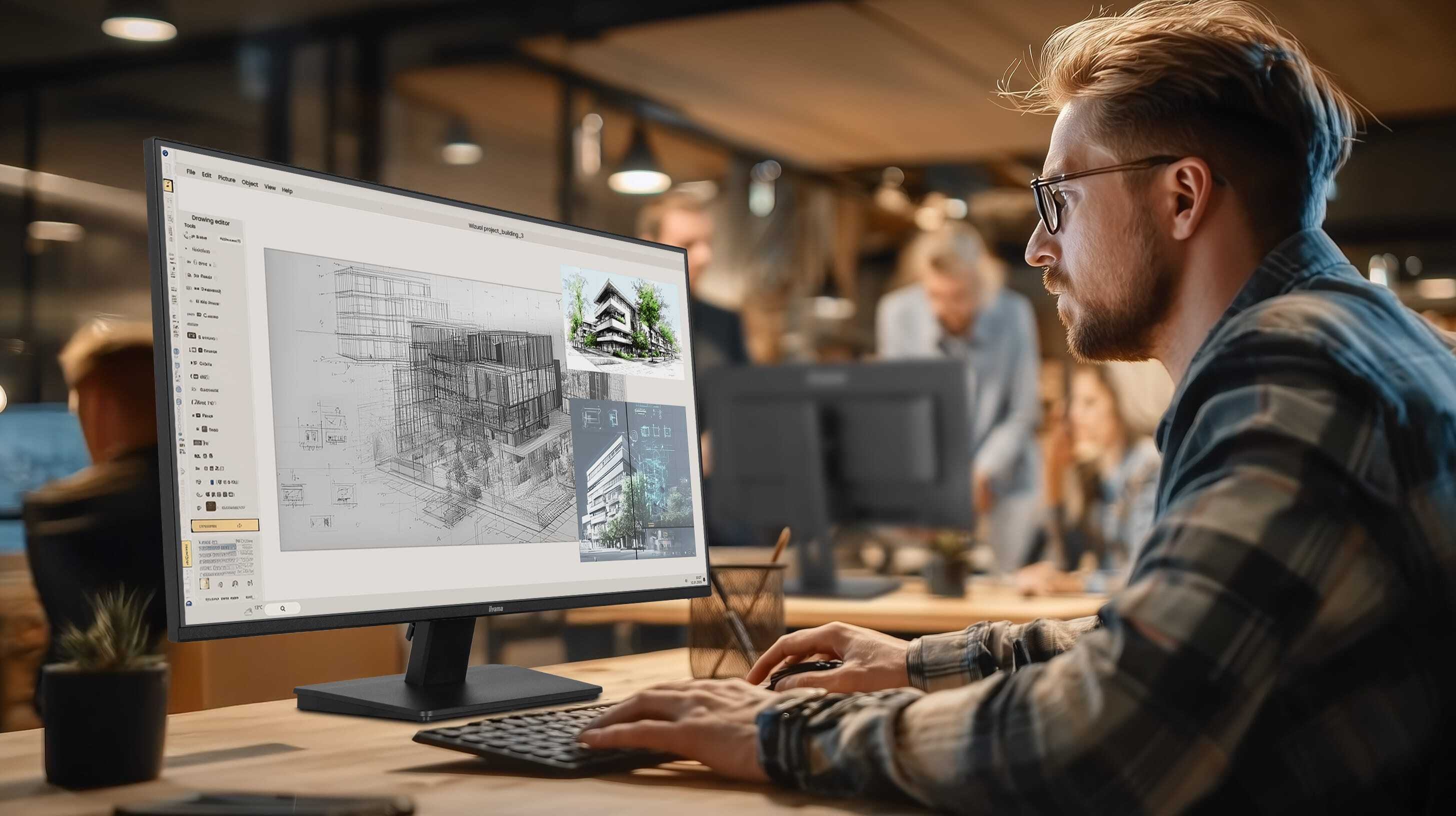 Mann arbeitet am Computer, der Architekturzeichnungen zeigt.