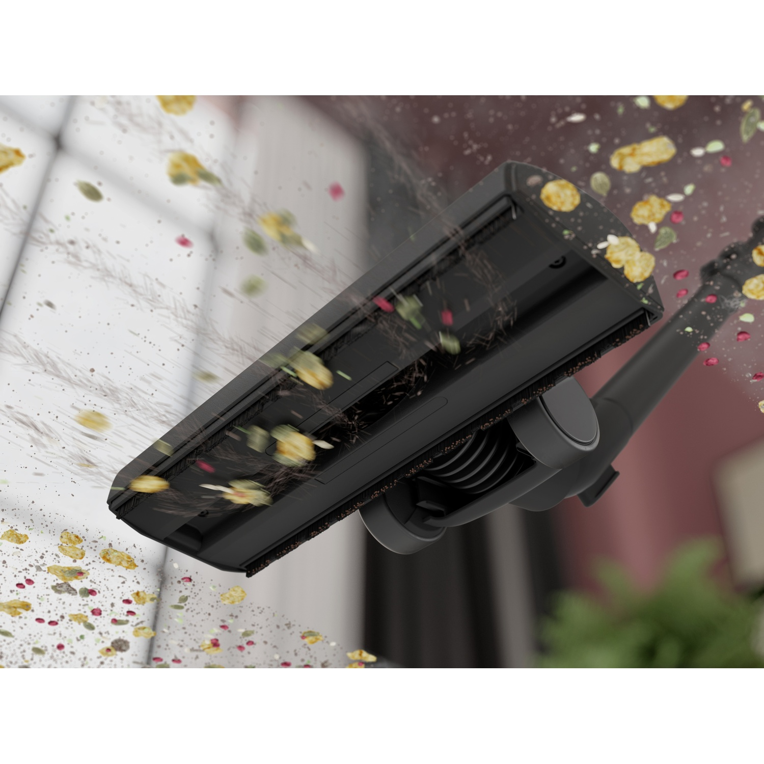 A black vacuum cleaner head sucks up dirt and crumbs.