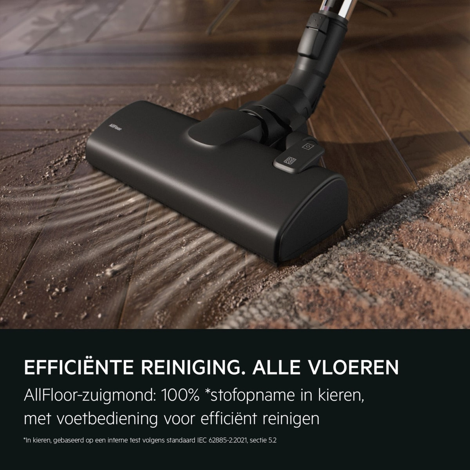 Black vacuum cleaner head cleaning dust and dirt from a wooden floor.