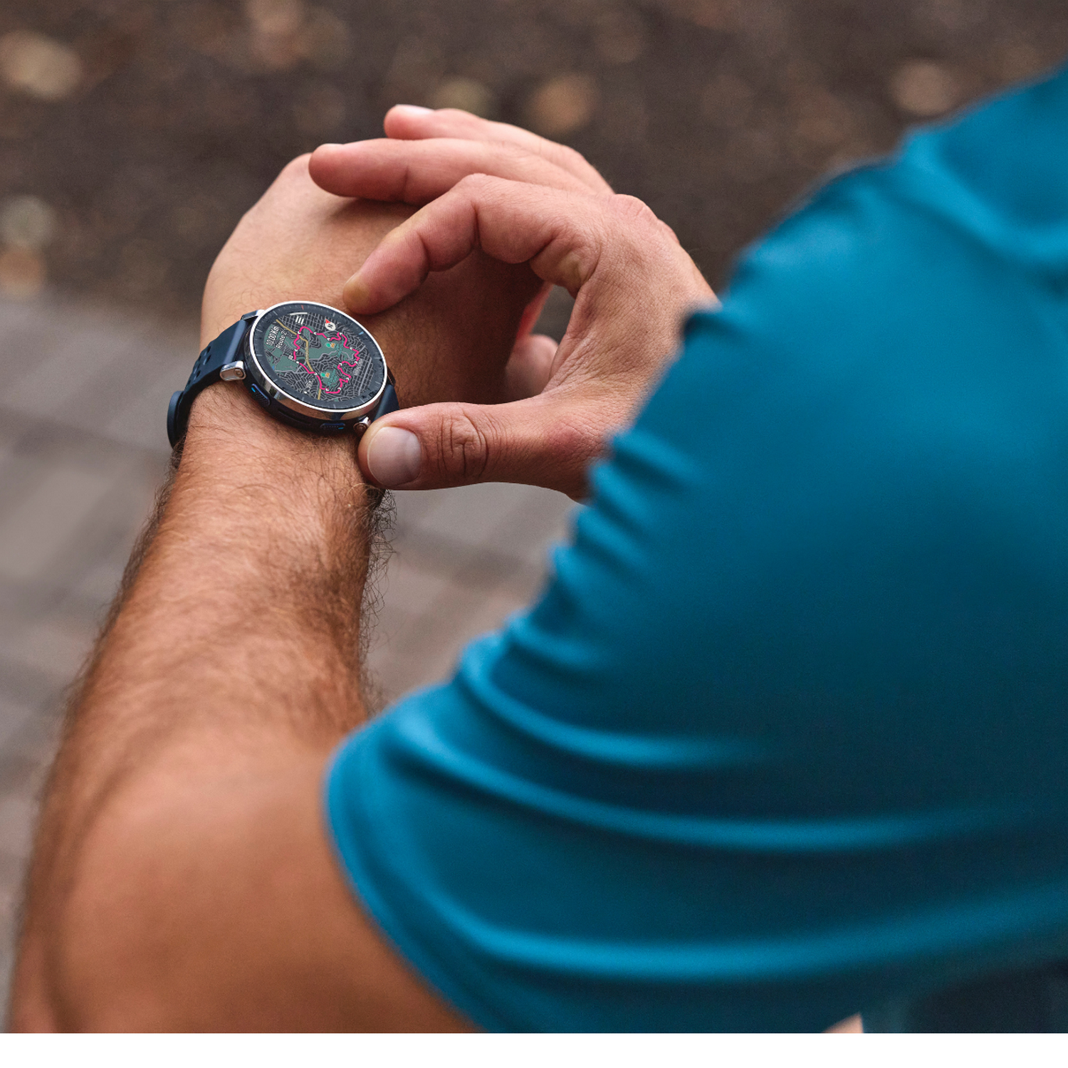 Hombre con camiseta azul revisa su reloj inteligente con pantalla colorida.