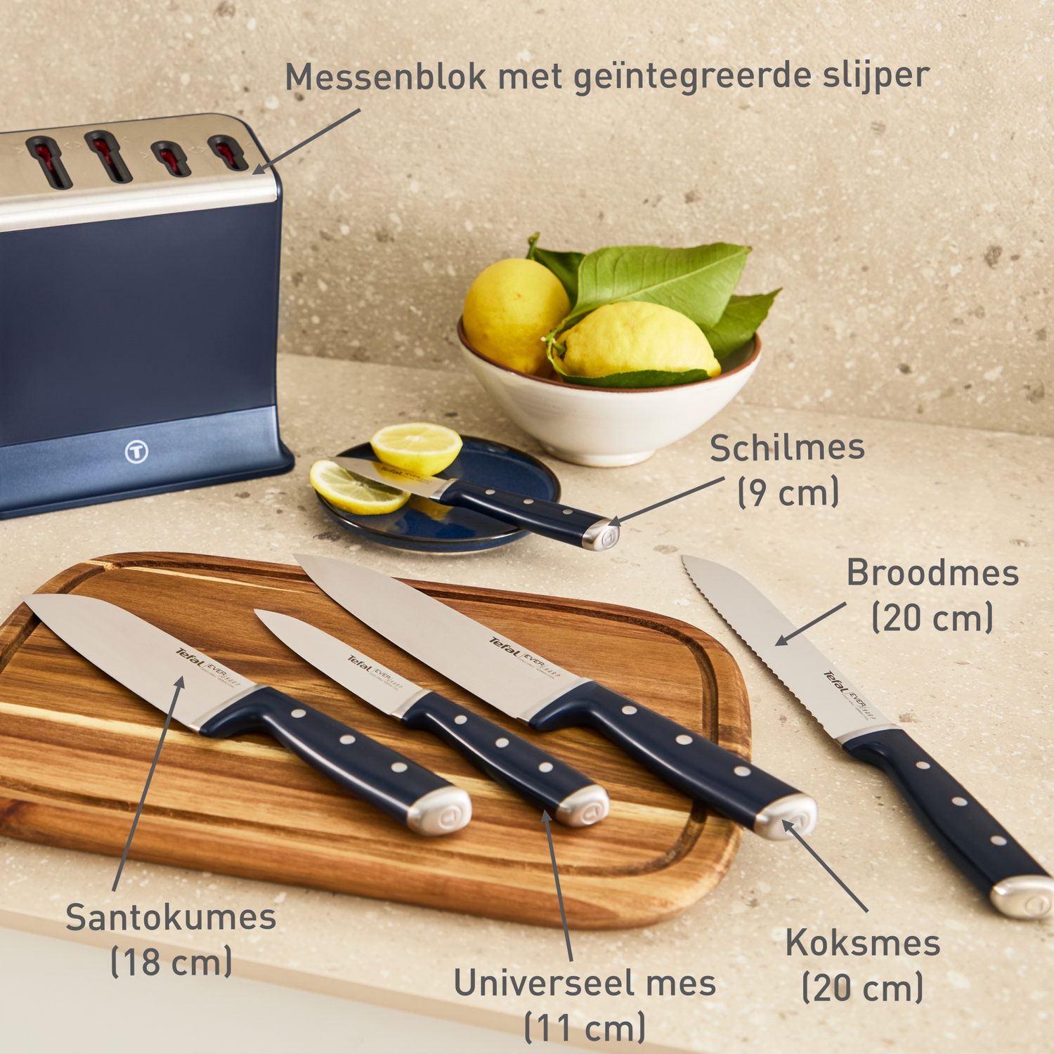 A knife block with sharpener, knives, and lemons on a wooden counter.