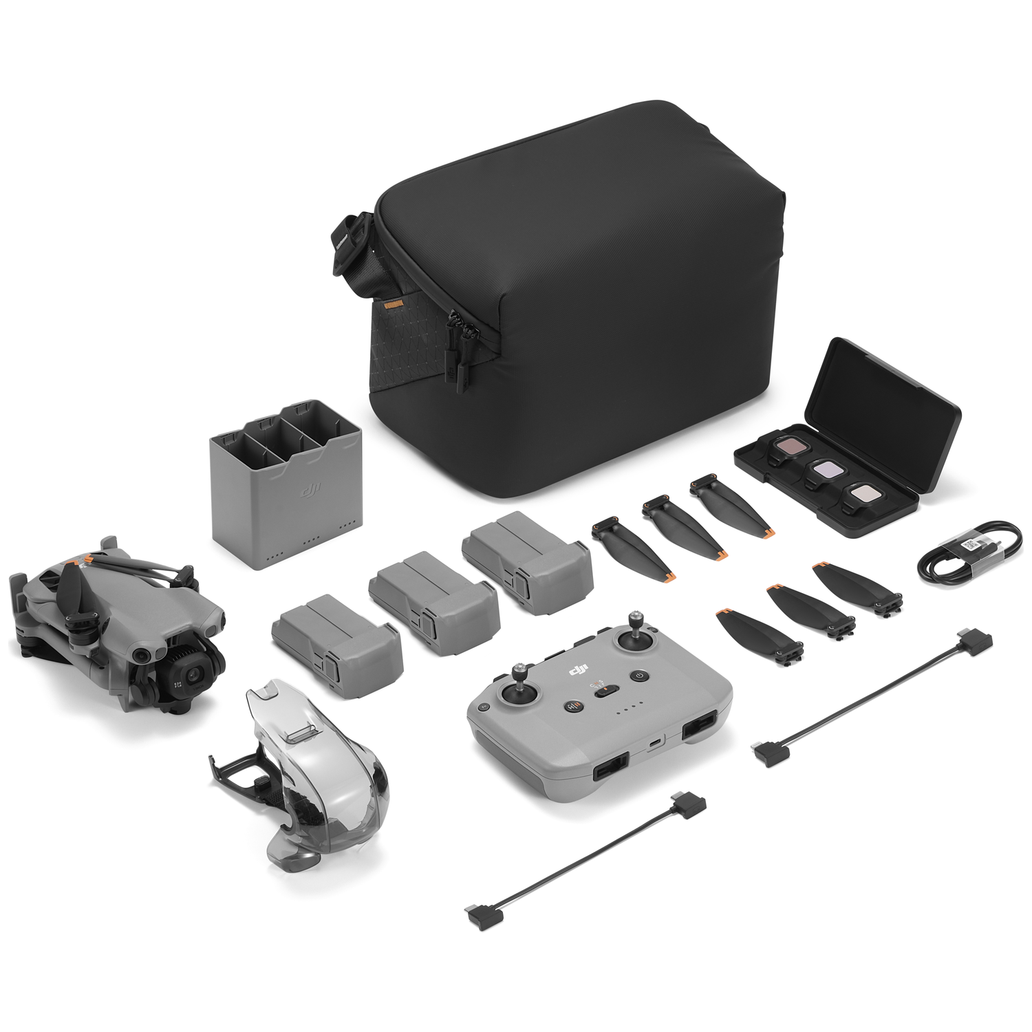 Grijze DJI drone kit met afstandsbediening, batterijen, propellers en tas.