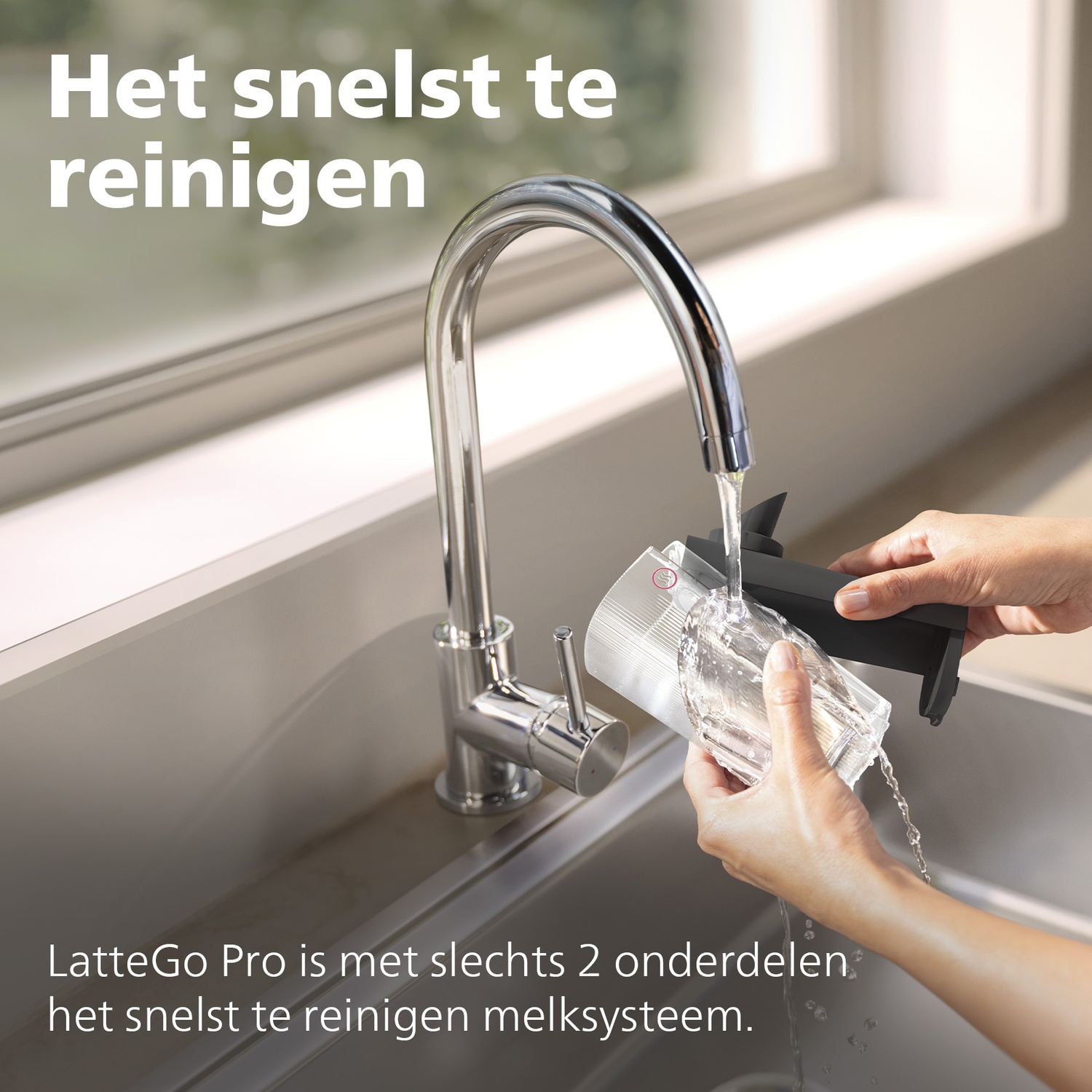A hand rinses a milk system part under running water.