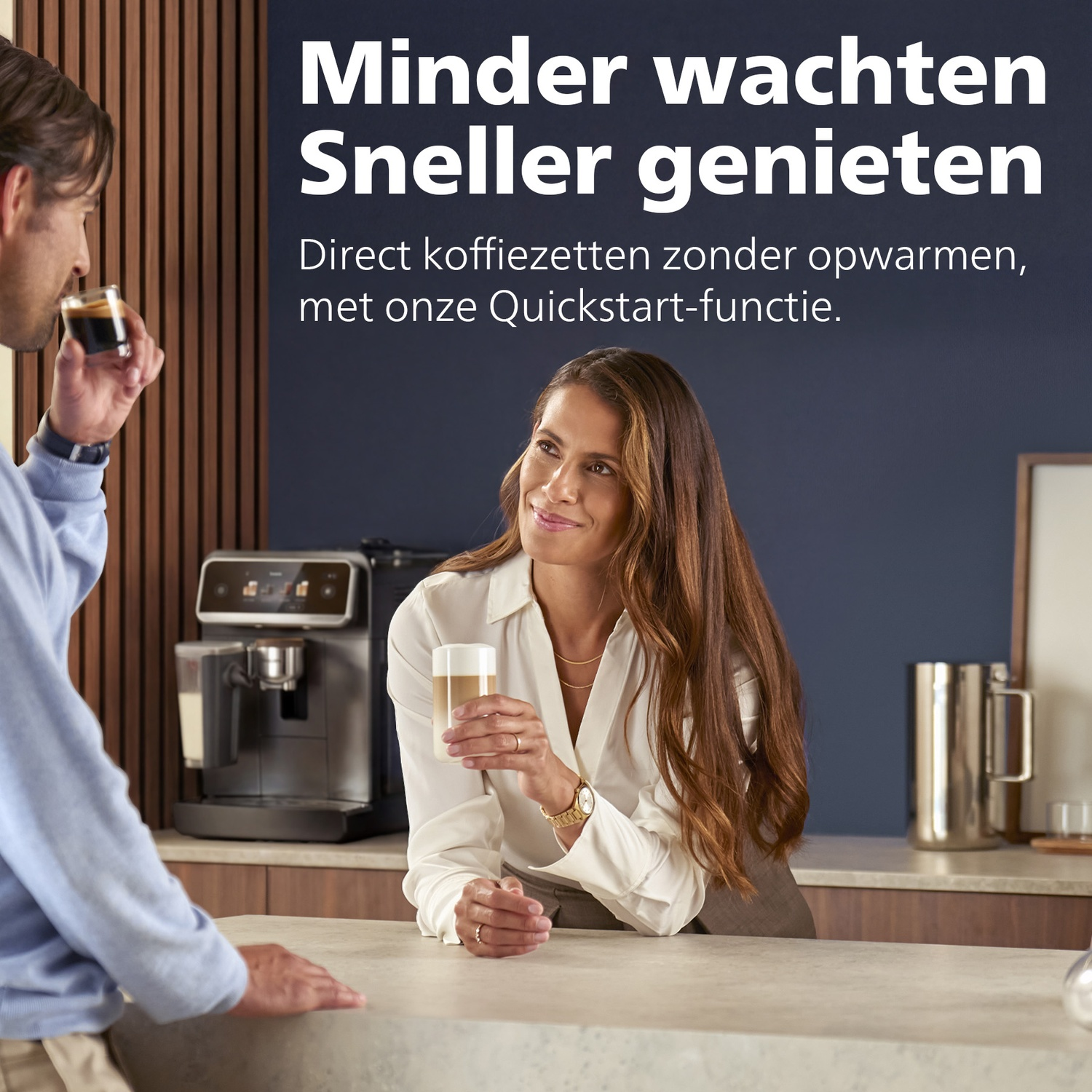 Man sips espresso, woman holds latte. Coffee machine in background.