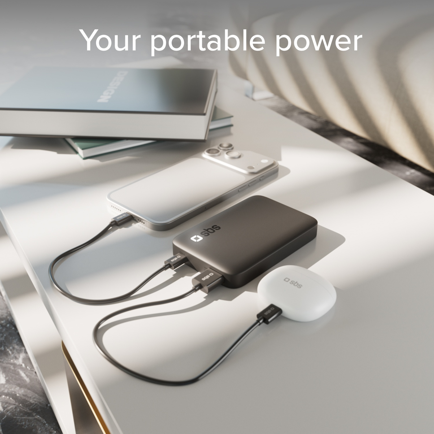 Een smartphone, powerbank en oordopjes op een tafel, verbonden door kabels.