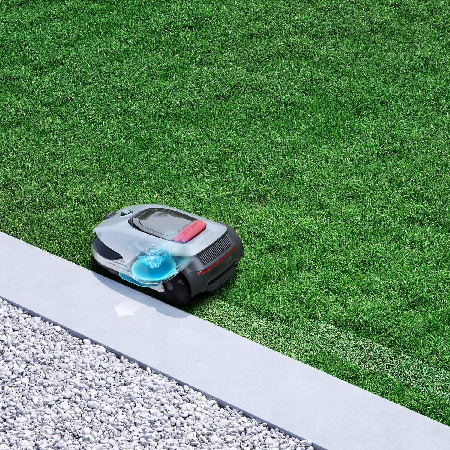 A robotic lawn mower trims a perfectly manicured lawn next to gravel and concrete.