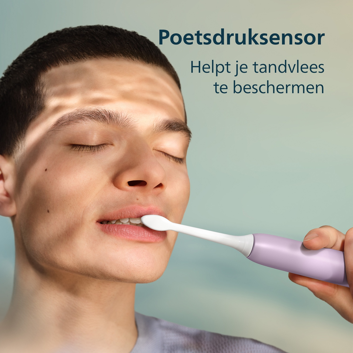 Man poetst tanden met paarse tandenborstel. Tekst: Poetsdruksensor.