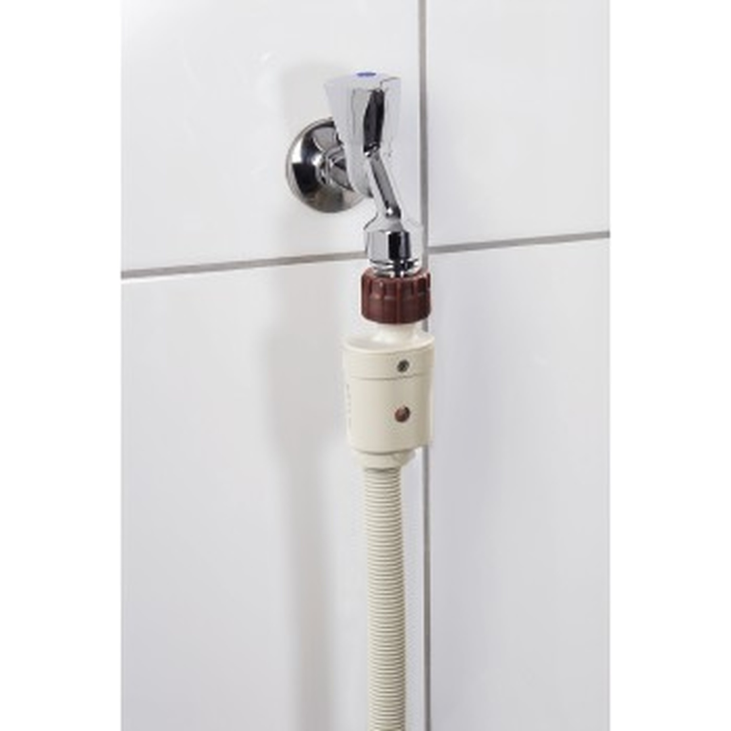 Een kraan met beige slangadapter en slang aan een witte betegelde muur.